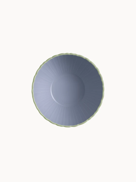 A top-down view on a two-toned ceramic bowl with a finely ribbed, mint  exterior and a smooth lavender interior, on a plain background.