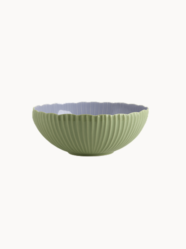 A two-toned ceramic bowl with a finely ribbed, mint  exterior and a smooth lavender interior, on a plain background.